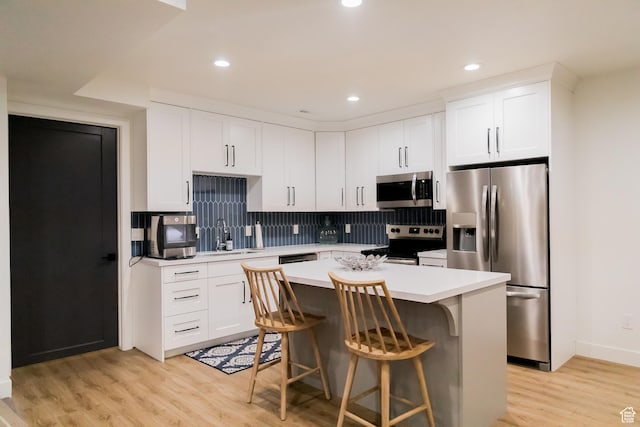 14102 S Sleepy Oaks Ln, Herriman, UT 84096 - kitchen featuring appliances with stainless steel finishes, light countertops, light wood finished floors, tasteful backsplash, and a kitchen island