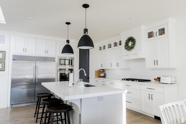 14102 S Sleepy Oaks Ln, Herriman, UT 84096 - kitchen with built in appliances, a sink, backsplash, a breakfast bar area, and light countertops