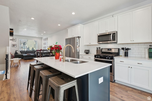 6643 W Skip Rock Rd S, South Jordan, UT 84009 - kitchen featuring appliances with stainless steel finishes, open floor plan, light countertops, and an island with sink