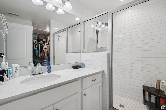 6643 W Skip Rock Rd S, South Jordan, UT 84009 - bathroom featuring a shower stall, a spacious closet, visible vents, and vanity