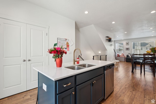 6643 W Skip Rock Rd S, South Jordan, UT 84009 - kitchen with a kitchen island with sink, a sink, light countertops, light wood-type flooring, and dishwasher