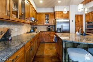 234 Ridge Ave, Park City, UT 84060 - kitchen with stainless steel appliances, brown cabinets, and glass insert cabinets