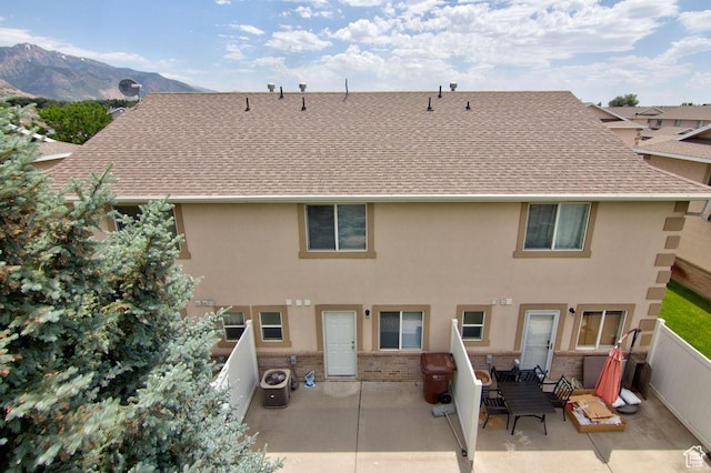 262 W 1975 N Unit 40, Ogden, UT 84414 - back of house featuring roof with shingles, brick siding, a patio area, a mountain view, and stucco siding