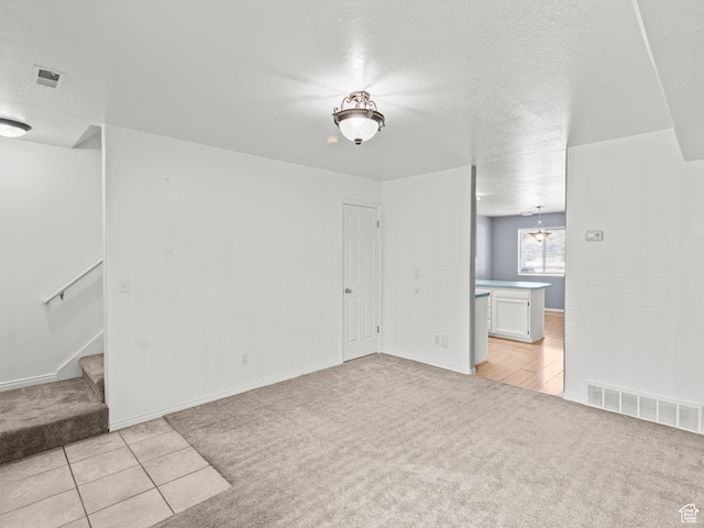 262 W 1975 N Unit 40, Ogden, UT 84414 - empty room with stairway, visible vents, a textured ceiling, and light colored carpet