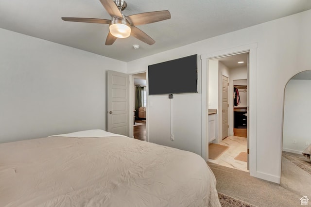 6393 N Pine Tree Way, Eagle Mountain, UT 84005 - bedroom featuring baseboards, ceiling fan, arched walkways, ensuite bath, and light colored carpet