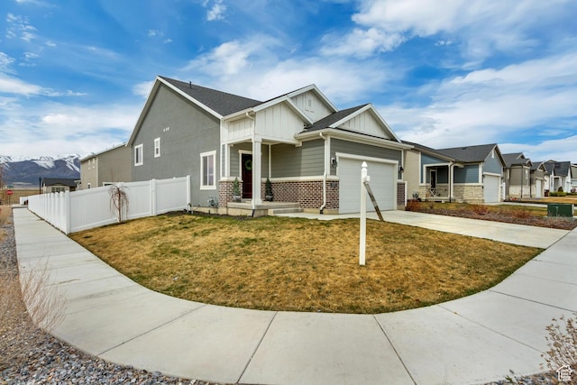 6393 N Pine Tree Way, Eagle Mountain, UT 84005 - view of front facade with driveway, a front yard, an attached garage, fence, and board and batten siding