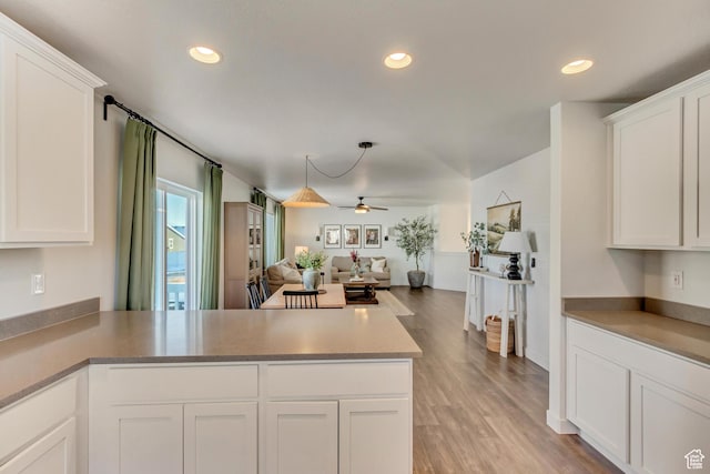 6393 N Pine Tree Way, Eagle Mountain, UT 84005 - kitchen featuring white cabinets, light wood-style flooring, a peninsula, ceiling fan, and open floor plan