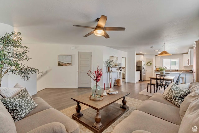 6393 N Pine Tree Way, Eagle Mountain, UT 84005 - living room featuring a ceiling fan, a textured ceiling, light wood-type flooring, baseboards, and recessed lighting