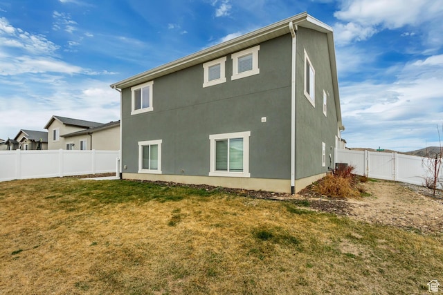 6393 N Pine Tree Way, Eagle Mountain, UT 84005 - back of house with a fenced backyard, stucco siding, and a yard