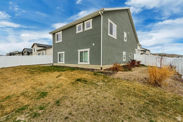 6393 N Pine Tree Way, Eagle Mountain, UT 84005 - rear view of house with a fenced backyard, stucco siding, and a lawn