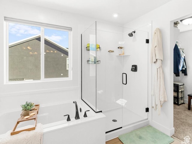 bathroom with a shower stall and a bath