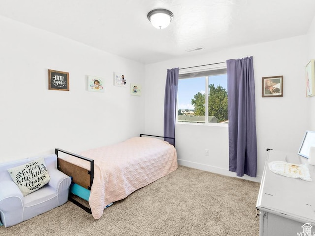 bedroom featuring baseboards, visible vents, and light colored carpet