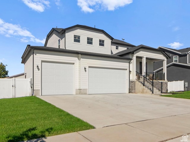 view of front of property featuring a garage, concrete driveway, a front yard, and fence