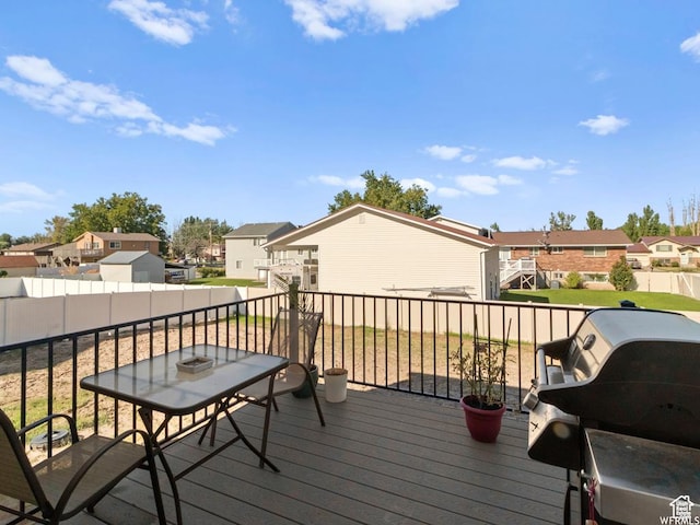 deck featuring area for grilling, fence, and a residential view