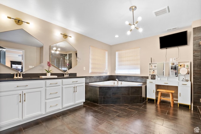 full bath featuring a sink, double vanity, a garden tub, and visible vents