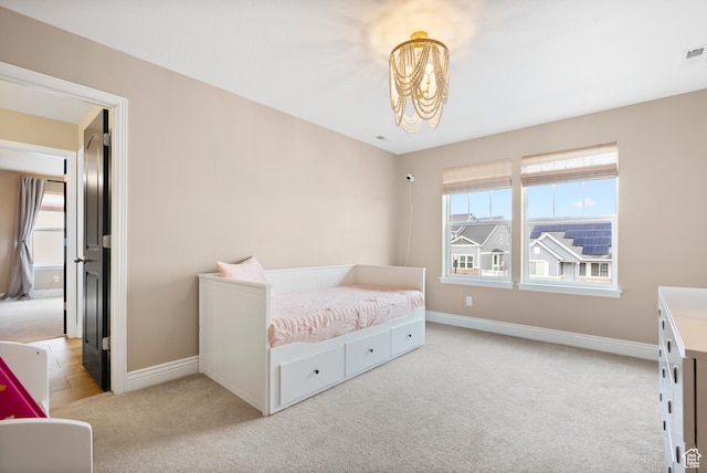 bedroom with baseboards, a notable chandelier, visible vents, and light colored carpet