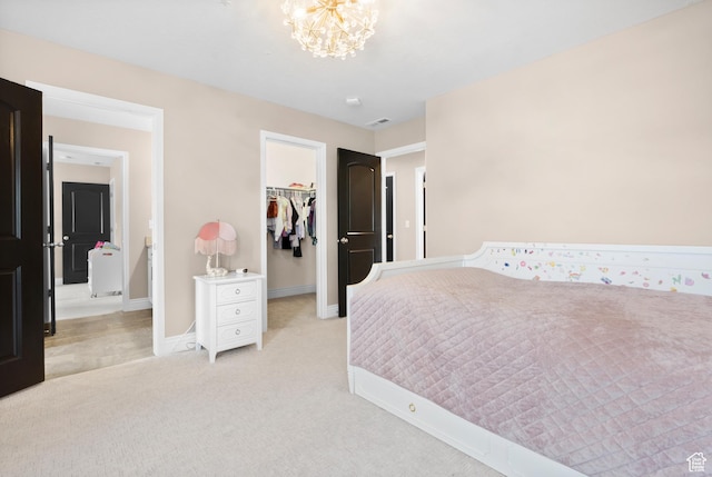 bedroom with a spacious closet, a chandelier, baseboards, light colored carpet, and a closet