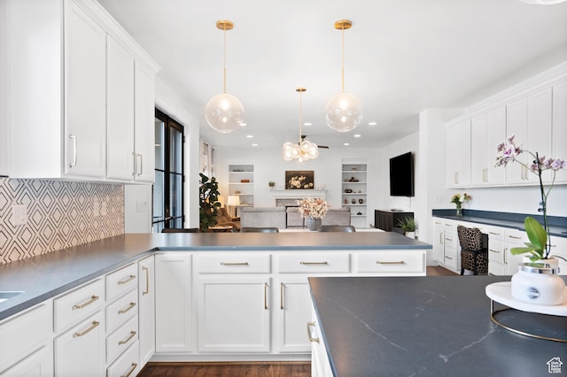 kitchen featuring white cabinets, decorative backsplash, dark countertops, open floor plan, and recessed lighting