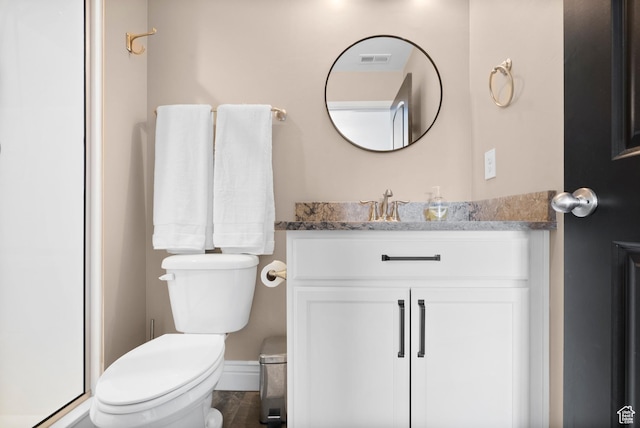 bathroom featuring vanity, toilet, and visible vents