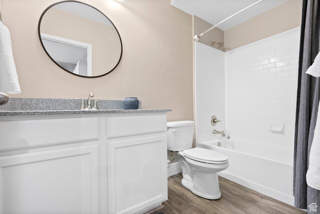 full bath with wood finished floors, toilet, vanity, and shower / washtub combination