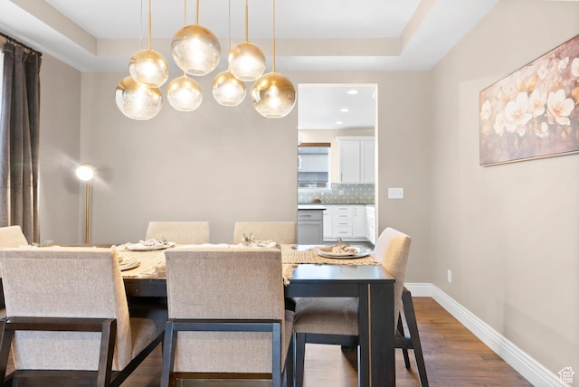 dining area with baseboards, a notable chandelier, and dark wood-type flooring
