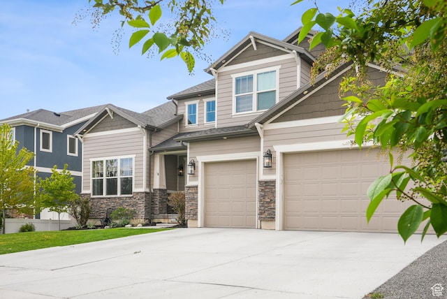 craftsman-style home with concrete driveway, stone siding, and a garage