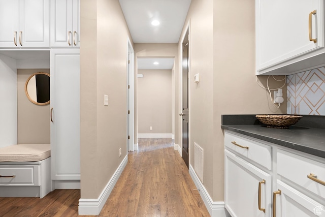 hall with light wood-style floors, baseboards, and recessed lighting