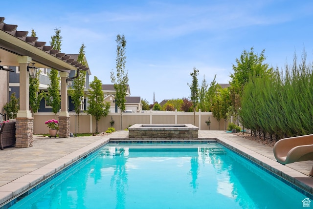view of pool featuring a water slide, a fenced backyard, a patio, and an in-ground hot tub