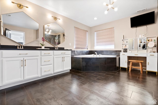 bathroom featuring a bath, double vanity, a chandelier, and tile patterned floors