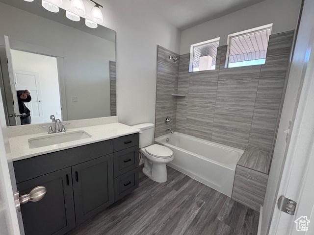 full bathroom featuring vanity,  shower combination, wood finished floors, and toilet