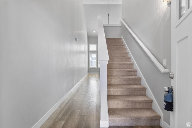 stairway with baseboards and wood finished floors