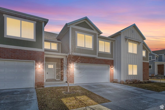 view of front of property featuring concrete driveway, a garage, brick siding, and board and batten siding