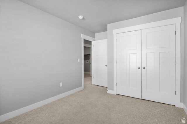 unfurnished bedroom featuring baseboards, carpet floors, and a closet