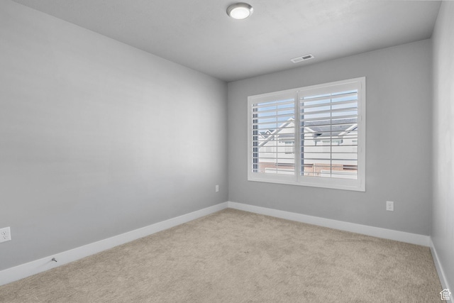 carpeted empty room featuring visible vents and baseboards