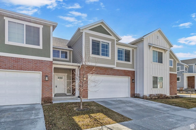 townhome / multi-family property featuring a garage, brick siding, board and batten siding, and concrete driveway