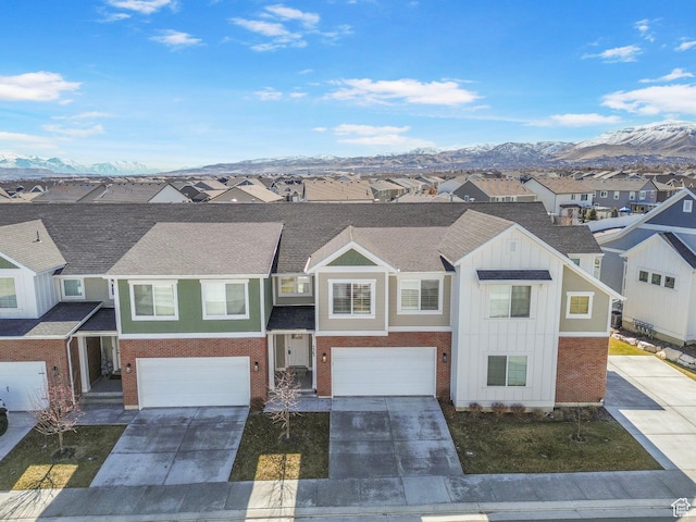 view of front of property featuring a mountain view, a residential view, brick siding, and concrete driveway