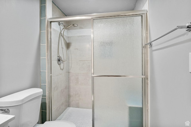 full bath featuring a shower stall and toilet