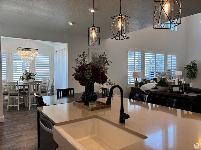 kitchen featuring dark wood finished floors, decorative light fixtures, a notable chandelier, and a sink