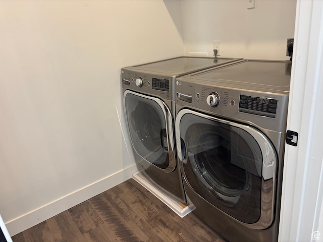 laundry room with dark wood finished floors, baseboards, laundry area, and independent washer and dryer