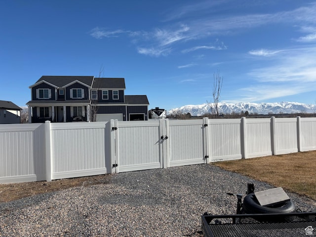 view of yard featuring a gate, fence, and a mountain view