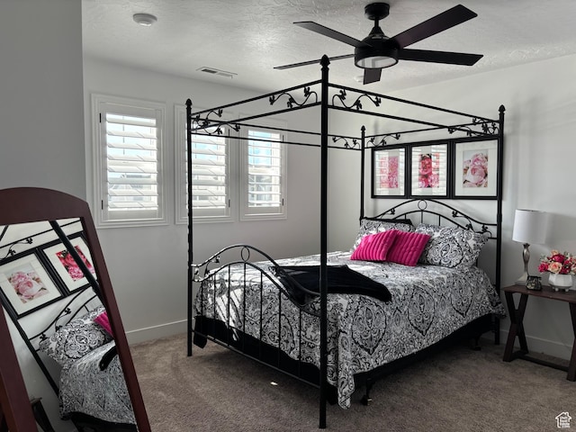 carpeted bedroom featuring ceiling fan, baseboards, a textured ceiling, and visible vents