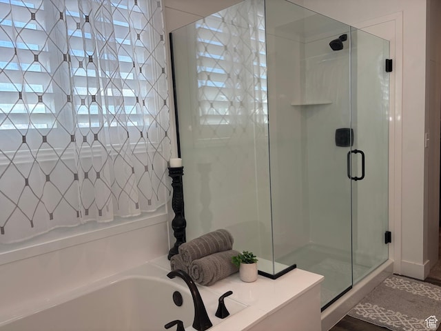 bathroom featuring a bath and a stall shower