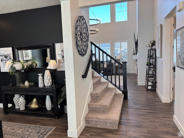 foyer with stairway, baseboards, wood finished floors, and a chandelier