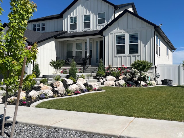 modern inspired farmhouse with board and batten siding, a front lawn, and covered porch
