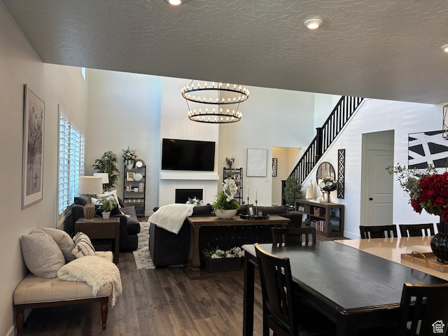 dining area with a textured ceiling, an inviting chandelier, a fireplace, dark wood finished floors, and recessed lighting