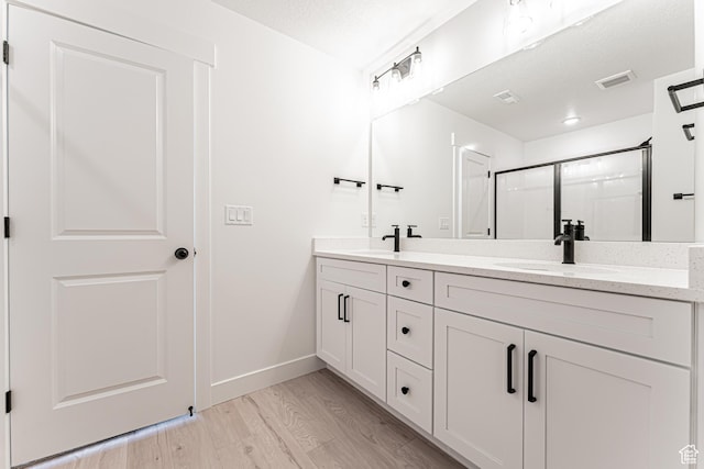706 W 4500 S Unit 307, Mapleton, UT 84664 - full bathroom featuring double vanity, wood finished floors, baseboards, and a shower with door