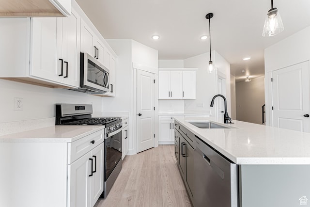 706 W 4500 S Unit 307, Mapleton, UT 84664 - kitchen with stainless steel appliances, a sink, light wood finished floors, an island with sink, and recessed lighting