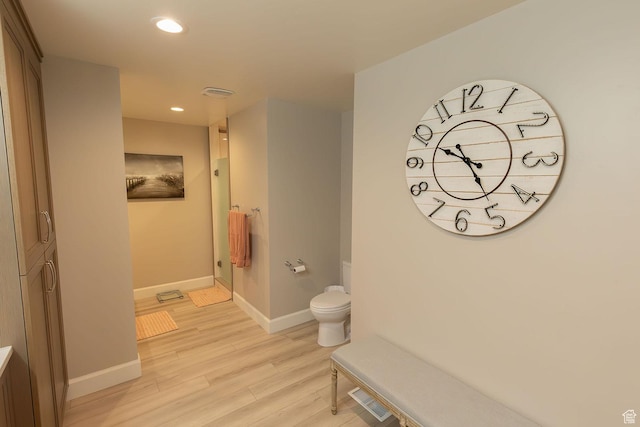 full bathroom with a shower, recessed lighting, toilet, wood finished floors, and baseboards