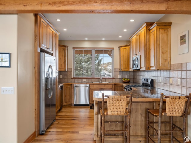 1173 S Innsbruck Dr, Huntsville, UT 84317 - kitchen featuring appliances with stainless steel finishes, a breakfast bar area, a peninsula, and recessed lighting