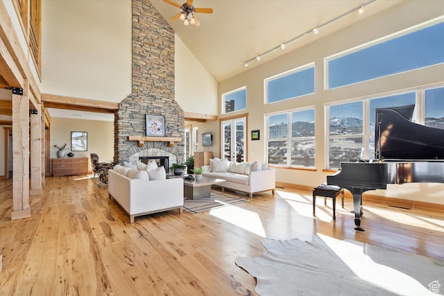 1173 S Innsbruck Dr, Huntsville, UT 84317 - living room featuring track lighting, wood finished floors, ceiling fan, a fireplace, and high vaulted ceiling